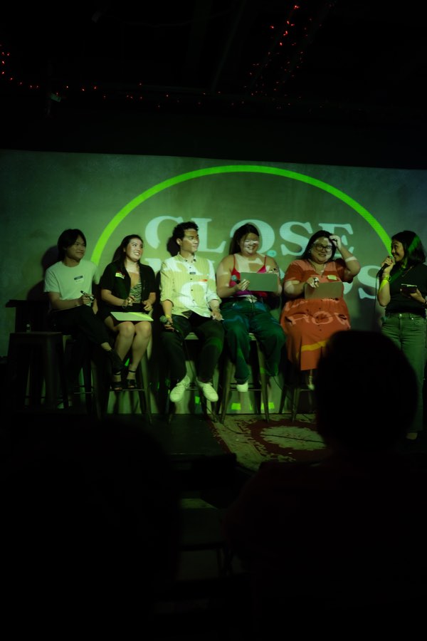 A crew of five on stage under the green ring
