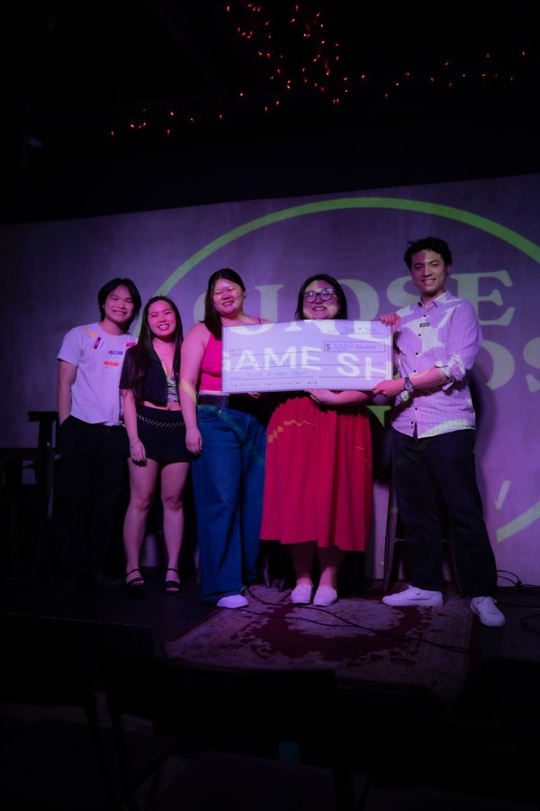 The winning crew hoisting the comically large check
